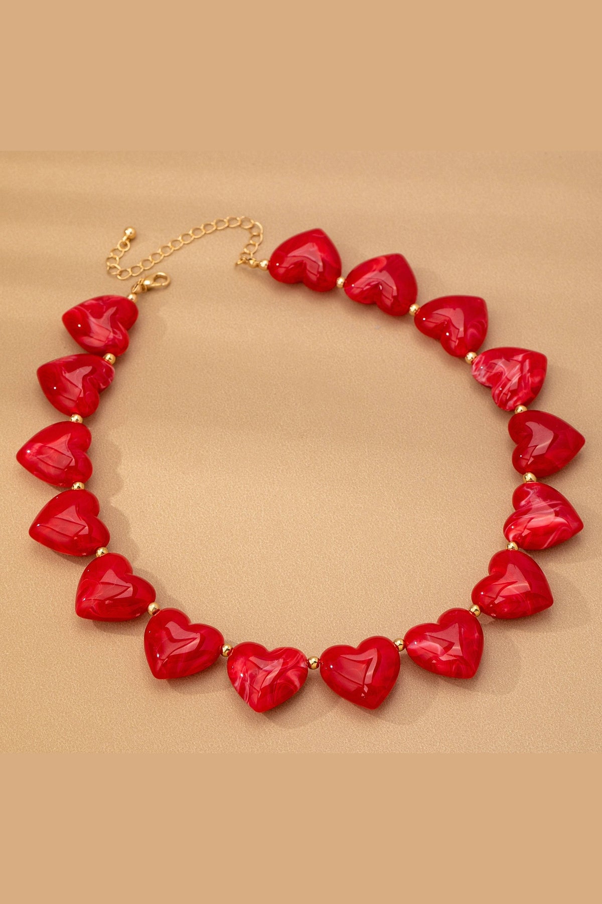 Heart Beaded Statement Necklace worn on a mannequin neck and upper chest, with small gold-toned spacer beads between the hearts.