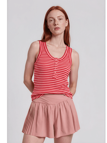 Woman wearing a red and white striped tank top and pink skirt on a light gray background