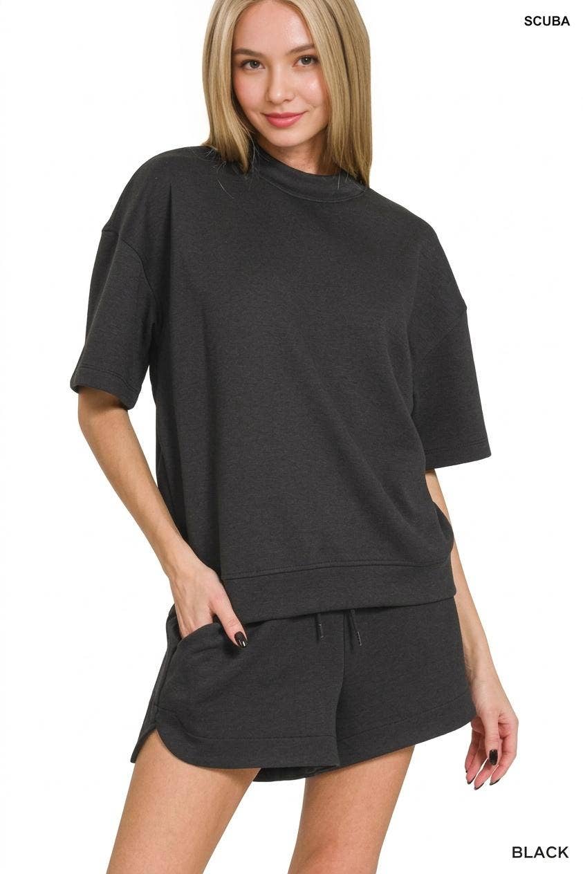 Woman wearing a black outfit with a matching top and shorts on a white background