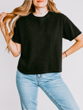 Person wearing a black t-shirt and blue jeans against a plain background