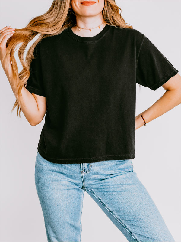 Person wearing a black t-shirt and blue jeans against a plain background