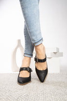 I’ll look at this product’s photos and write alt text to match.

Black western mule heels with pointed toes, embossed detailing, studded buckle straps, and stacked-look block heels, worn with cuffed jeans.