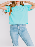 Person wearing a light blue t-shirt and jeans against a white background