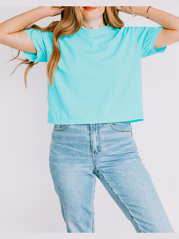 Person wearing a light blue t-shirt and jeans against a white background