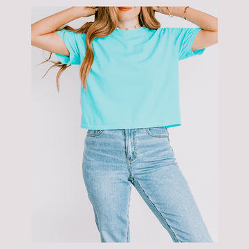 Person wearing a light blue t-shirt and jeans against a white background