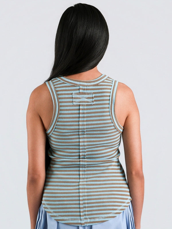 Woman wearing a striped tank top against a plain background
