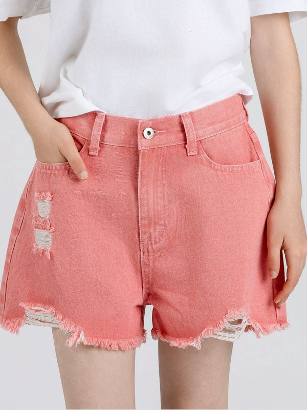 Person wearing pink denim shorts with a white background