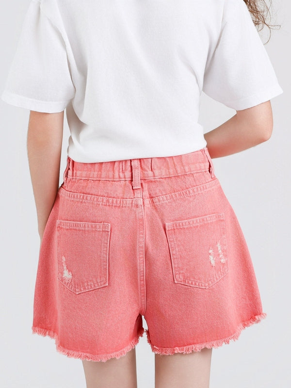 Person wearing pink denim shorts with a white background