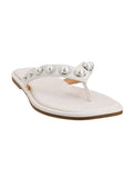 White sandal with pearl embellishments on a white background