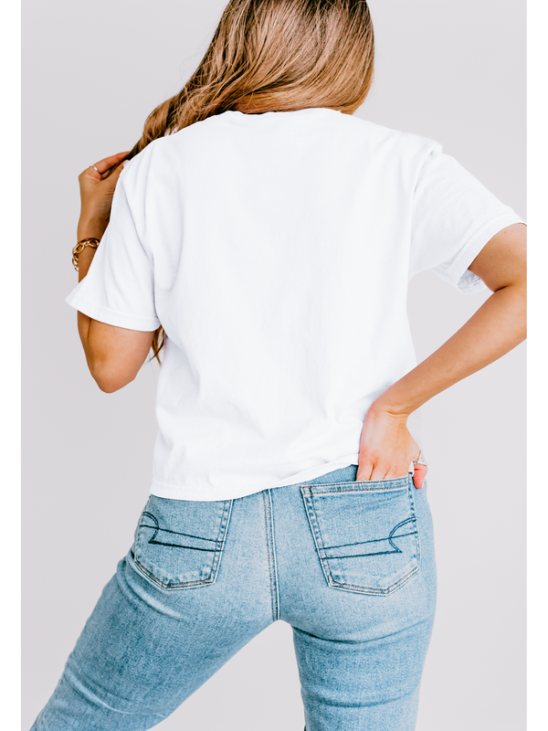 Person wearing a plain white t-shirt and blue jeans against a light gray background