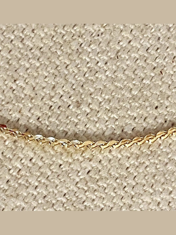 Gold chain on a textured beige background