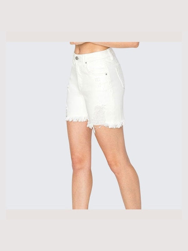Person wearing white denim shorts and cream ankle boots on a light gray background