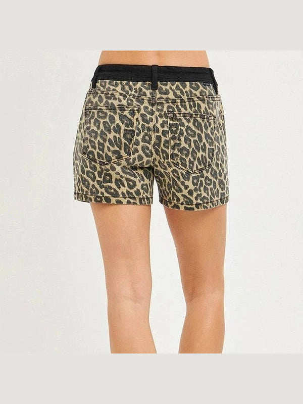 Leopard print shorts with a black belt on a plain background